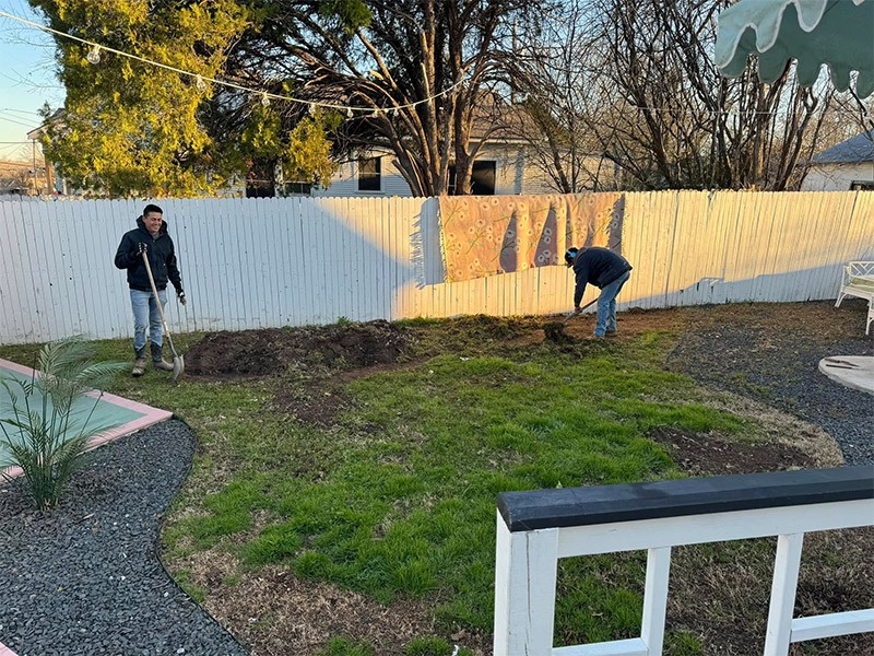 photo of a backyard getting the soil ripped up to place turf