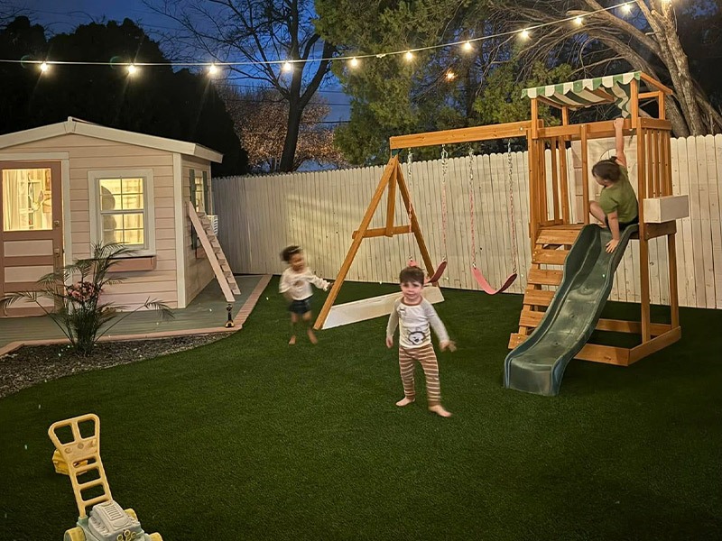 backyard with new turf and kids playing